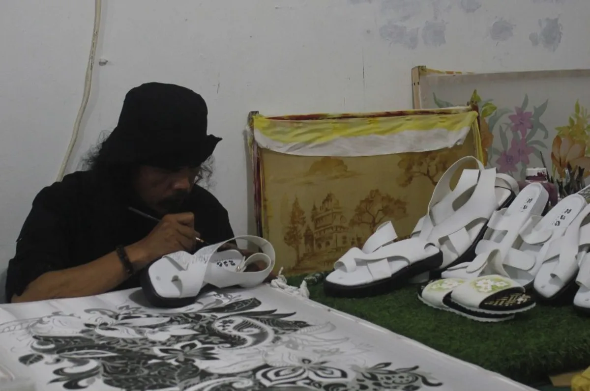 Proses melukis sandal geulis. (Foto: Rizma Riyandi)