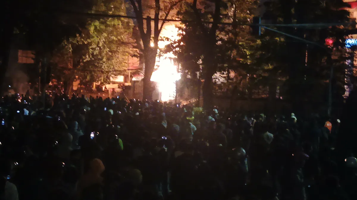 Suasana di depan Gedung DPRD Jawa Barat pada Jumat, 29 Juli 2025. Tampak kobaran api dari wisma MPR. (Sumber: Ayobandung | Foto: Gilang Fathu Romadhan)
