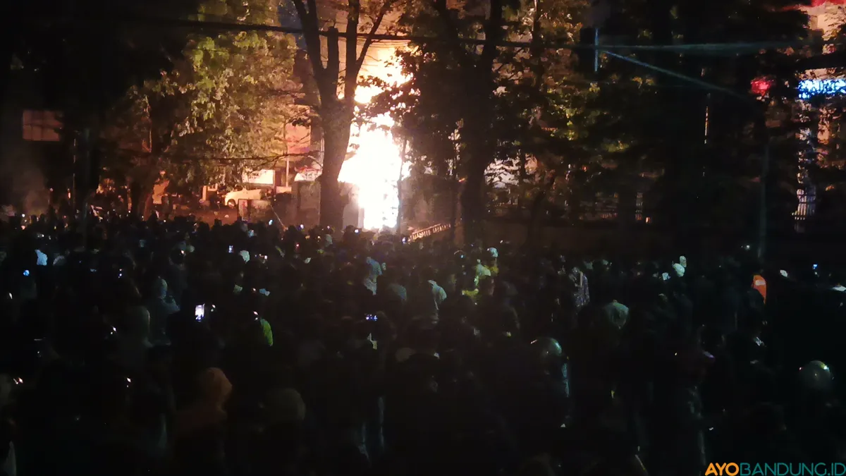 Suasana di depan Gedung DPRD Jawa Barat pada Jumat, 29 Juli 2025. Tampak kobaran api dari mess MPR. (Sumber: ayobandung.id | Foto: Gilang Fathu Romadhan)