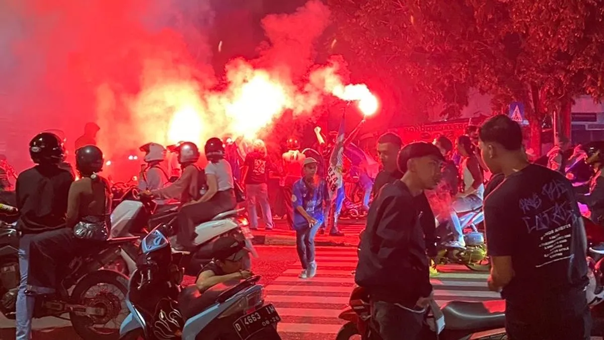 Bobotoh menyalakan flare di Tengah keramaian dengan banyak pengendara tampak tidak mematuhi aturan lalu lintas.  
Minggu malam, 25 Mei 2025 (foto: sumber della titya)