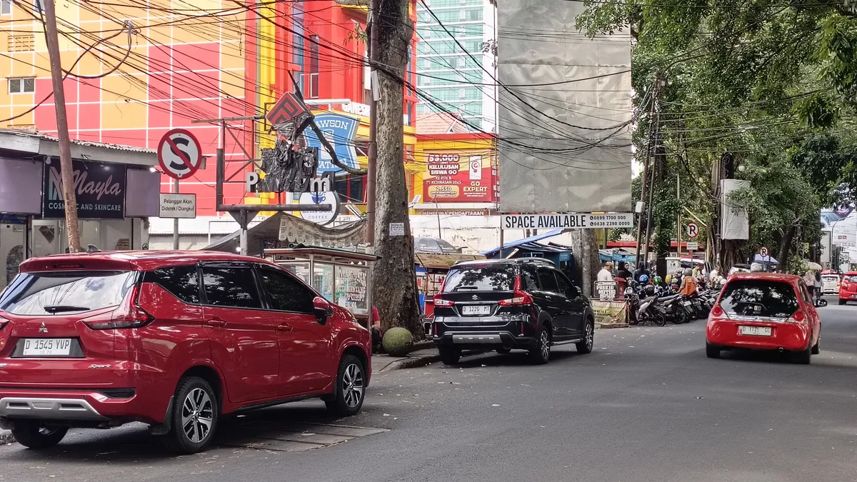 Kendaraan yang sedang parkir di bawah rambu lalu lintas dilarang berhenti di Jalan Mulawarman pada siang hari, pada tanggal 3 Desember 2025 (Sumber: Davi Rivaldo Ramadhan Hidayat) (Sumber: Dokumentasi Pribadi | Foto: Davi Rivaldo Ramadhan Hidayat)