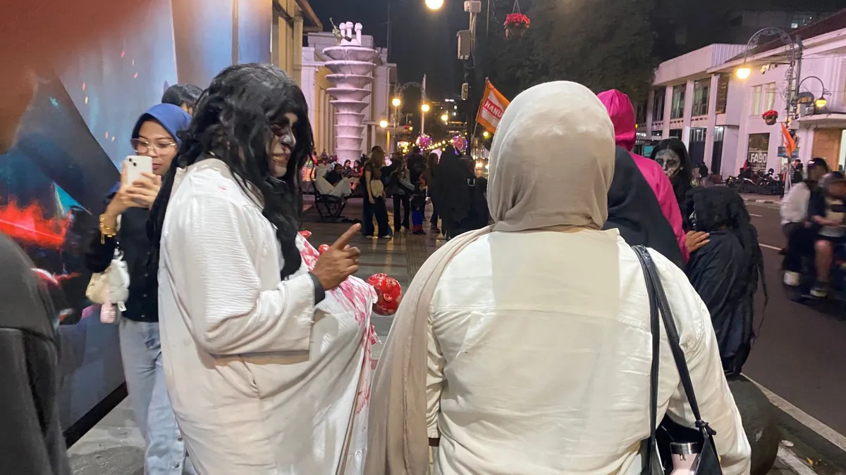 Suasana malam di pusat kota Bandung terganggu oleh kehadiran pengamen berkostum yang kerap memaksa meminta uang, 02/12/2025 (Foto: Hakim)