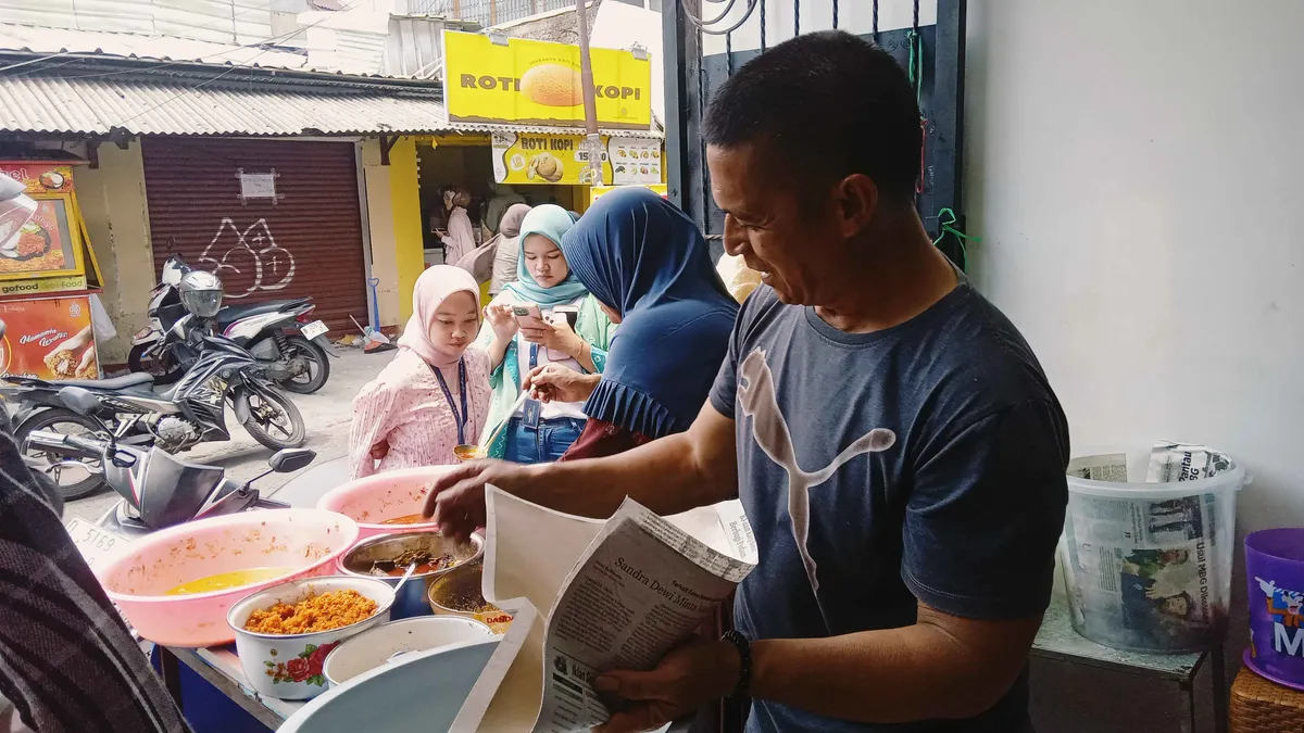 Suami Bu Mun sigap membungkus pesanan, memastikan sampai di tangan pelanggan. (Sumber: Dokumen Pribadi | Foto: Annisa Fitri Ramadhani)