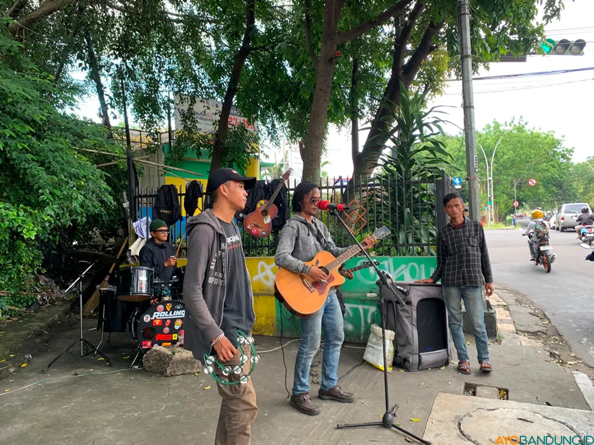 Penyanyi jalanan di Jalan Pahlawan dalam sehari bisa mengumpulkang uang Rp70.000 sampai Rp100.000 meski dihantui rasa waswas diamankan Satpol PP. (Sumber: ayobandung.id | Foto: Halwa Raudhatul)