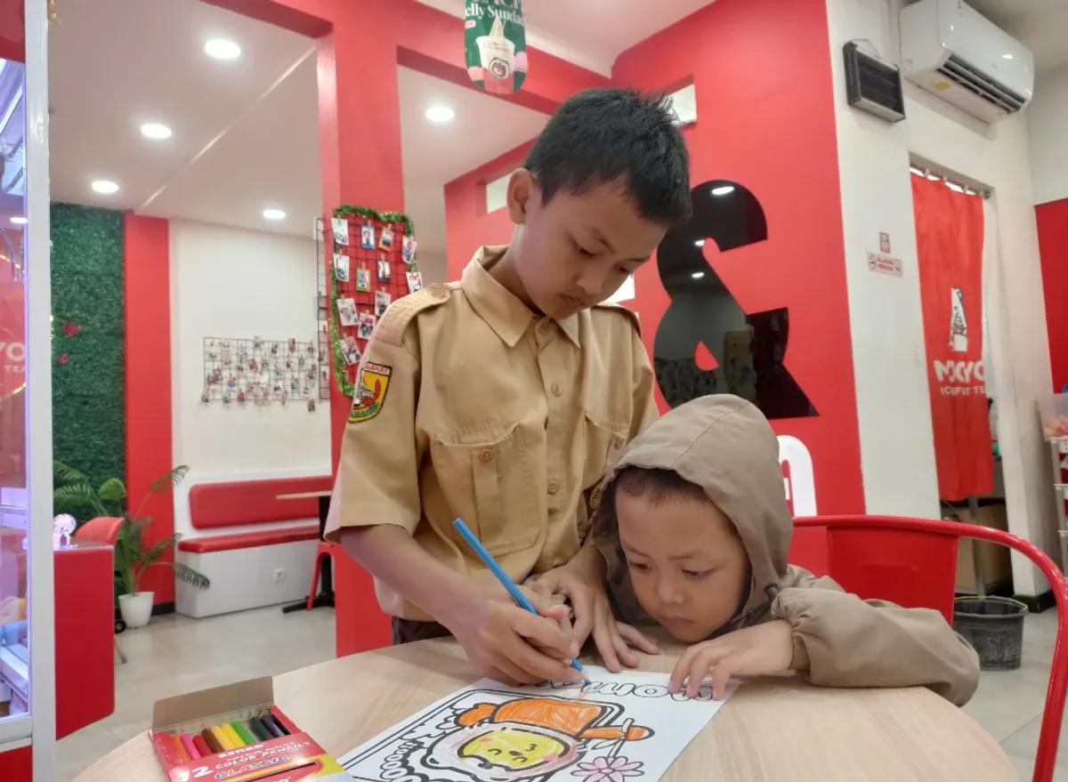 Aa Akil dan Kakang tengah asyik mewarnai di salah satu gerai es krim di Cipadung, Selasa 22 Juli 2025 (Sumber: Istimewa | Foto: IBN GHIFARIE)