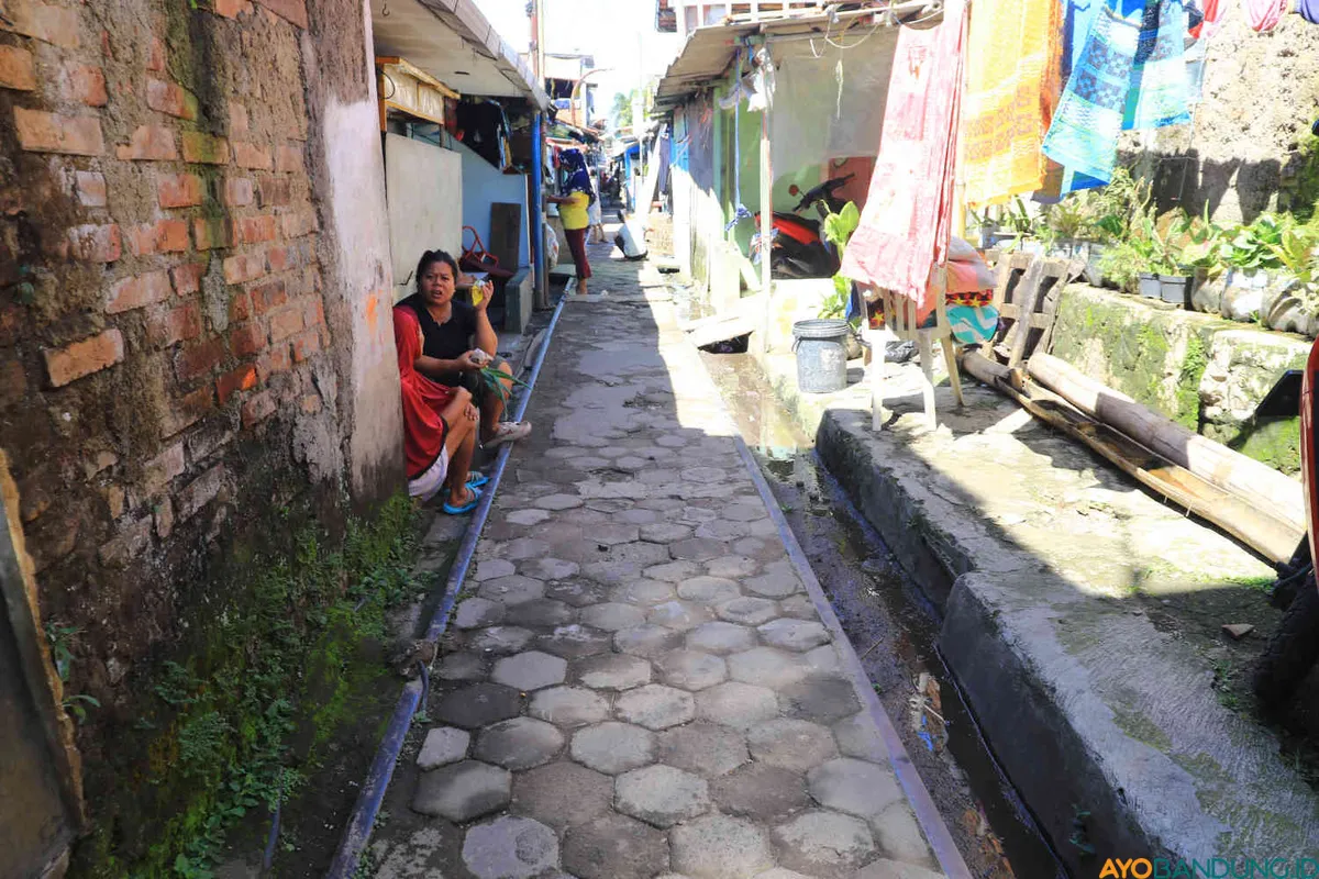 Warga beraktifitas di rel kereta api rute Cikudapateuh-Ciwidey yang sudah tidak aktif, Jalan Ciparay, Kelurahan Kujangsari, Kec. Bandung Kidul, Kota Bandung, Senin 28 April 2025. (Sumber: ayobandung.id | Foto: Irfan Al-Faritsi)