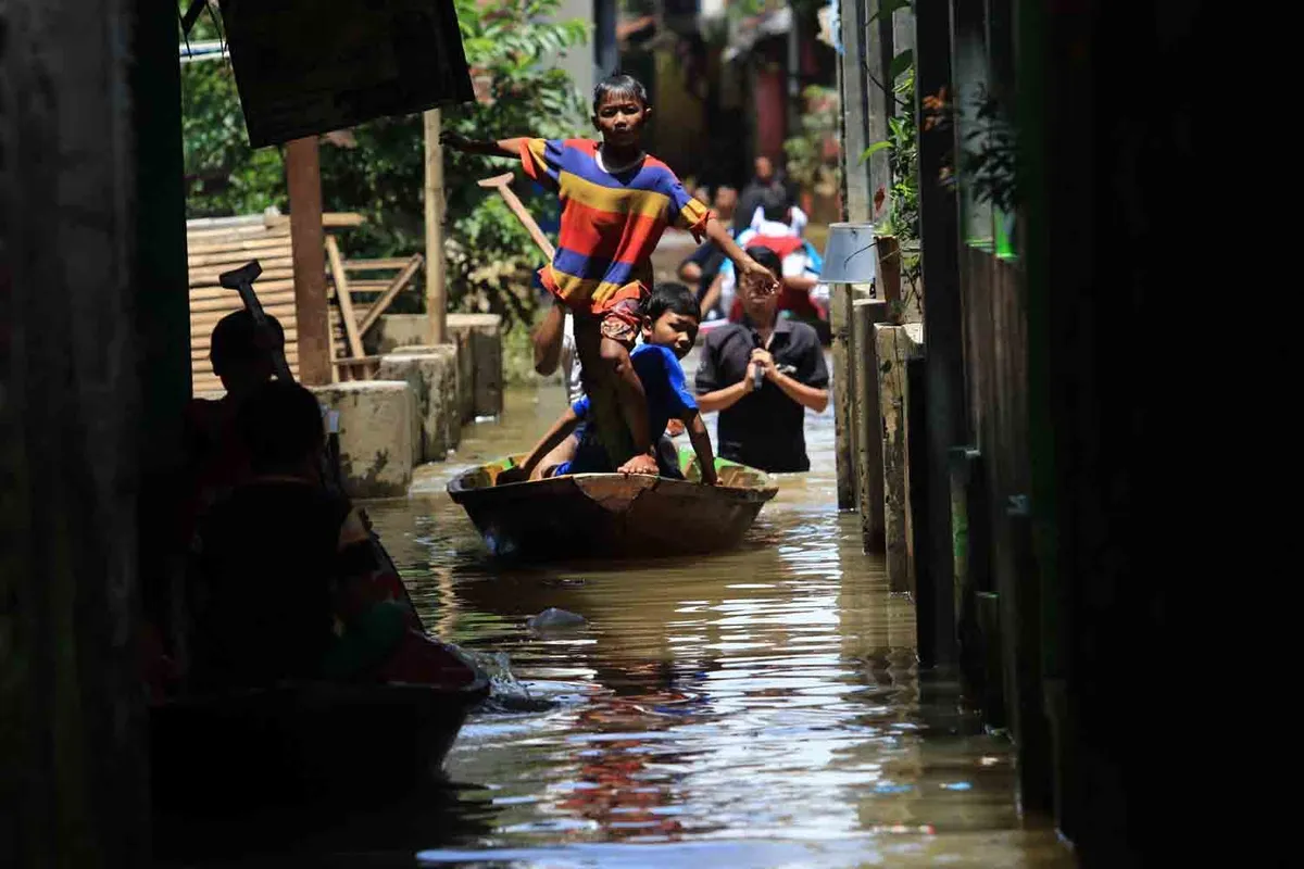 Sejumlah bocah menaiki perahu saat banjir di Baleendah. (Sumber: Ayobandung | Foto: Irfan al Faritsi)