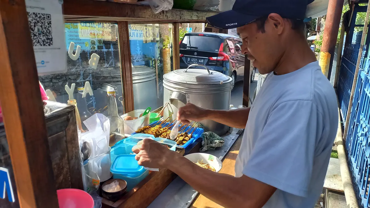 Mang Opik sedang menyiapkan semangkuk bubur ayam kepada pembeli (Sumber: Dokumentasi Pribadi Penulis | Foto: Salsabiil Firdaus)