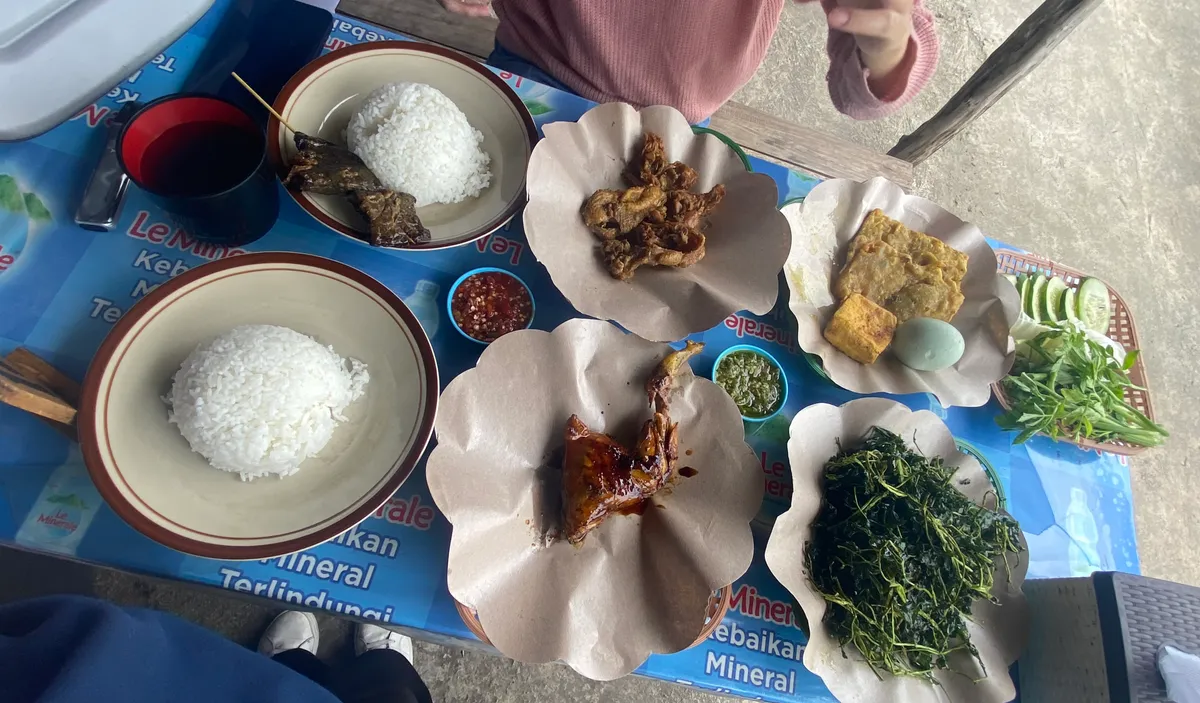 Kami sedang menikmati berbagai hidangan lengkap khas Sunda (nasi, ayam bakar, sate kulit, selada air, dan lalapan) dengan sambal pedas sebagai pelengkap. (04/11/25) (Sumber: Alfina Nurhasanah | Foto: Alfina Nurhasanah)