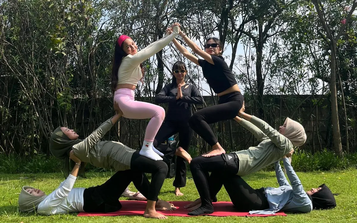 Peserta melakukan atraksi yoga di taman terbuka saat sesi latihan pagi yang diadakan oleh Sanggar Senam Vinisa Podomoro Park, Kabupaten Bandung pada Minggu (2/11/2025). (Foto: Wan Maulida Kusuma Syazci) (Sumber: Wan Maulida Kusuma Syazci | Foto: Wan Maulida Kusuma Syazci)