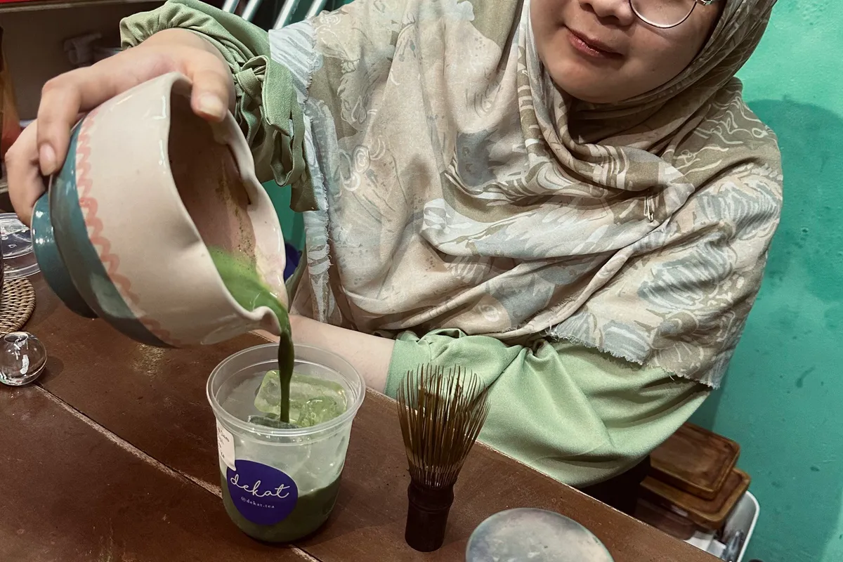 Arien Kartika Sari, pemilik Teh Dekat, sedang menyiapkan menu best seller mereka yaitu matcha di Pasar Cihapit, Jalan Cihapit, Kecamatan Bandung Wetan, Kota Bandung, Jawa Barat (2/11/2025) (Sumber: Venecia Fiantika | Foto: Venecia Fiantika)