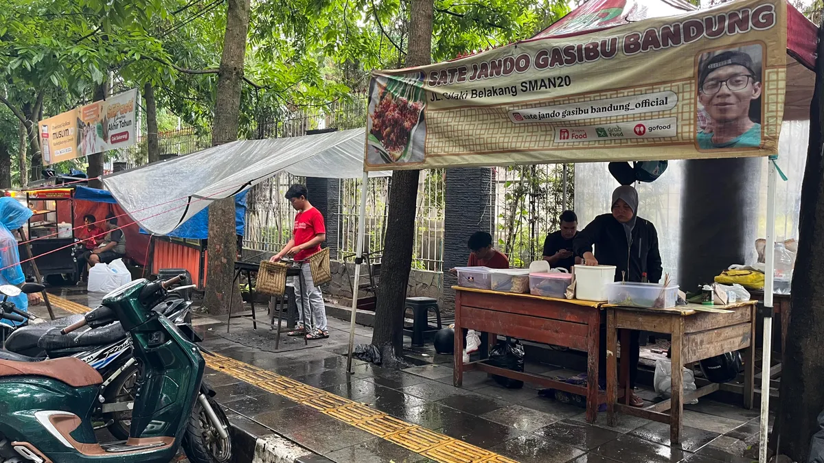 Meskipun hujan, pedagang menyajikan sate jando di tepi trotoar Jalan Cilaki, Kecamatan Bandung Wetan, Kota Bandung, Sabtu sore 1 November 2025 (Sumber: Novrandi Aqilah | Foto: Novrandi Aqilah)