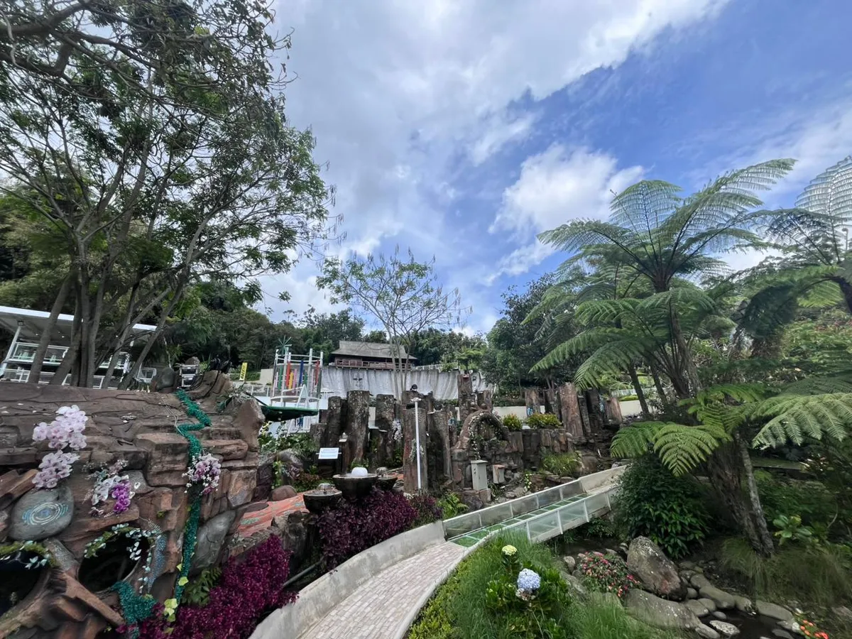 Pemandangan sekitar Water Coaster Dusun Bambu menampilkan perpaduan taman hijau, bebatuan alami, dan langit biru yang menciptakan suasana asri serta menenangkan. Di Jalan Kolonel Masturi KM 11, Desa Kertawangi, Kecamatan Cisarua, Kabupaten Bandung Barat, (06/11/2025). (Foto: Manda Navizalita)