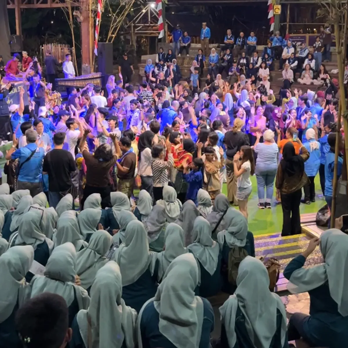 Sebagian penonton turun ke panggung pertunjukan untuk bersenang - senang dan menyaksikan pertunjukan musik dan tarian di panggung Saung Angklung Udjo Selasa (11/03/2025). (Sumber: Dokumentasi Penulis)