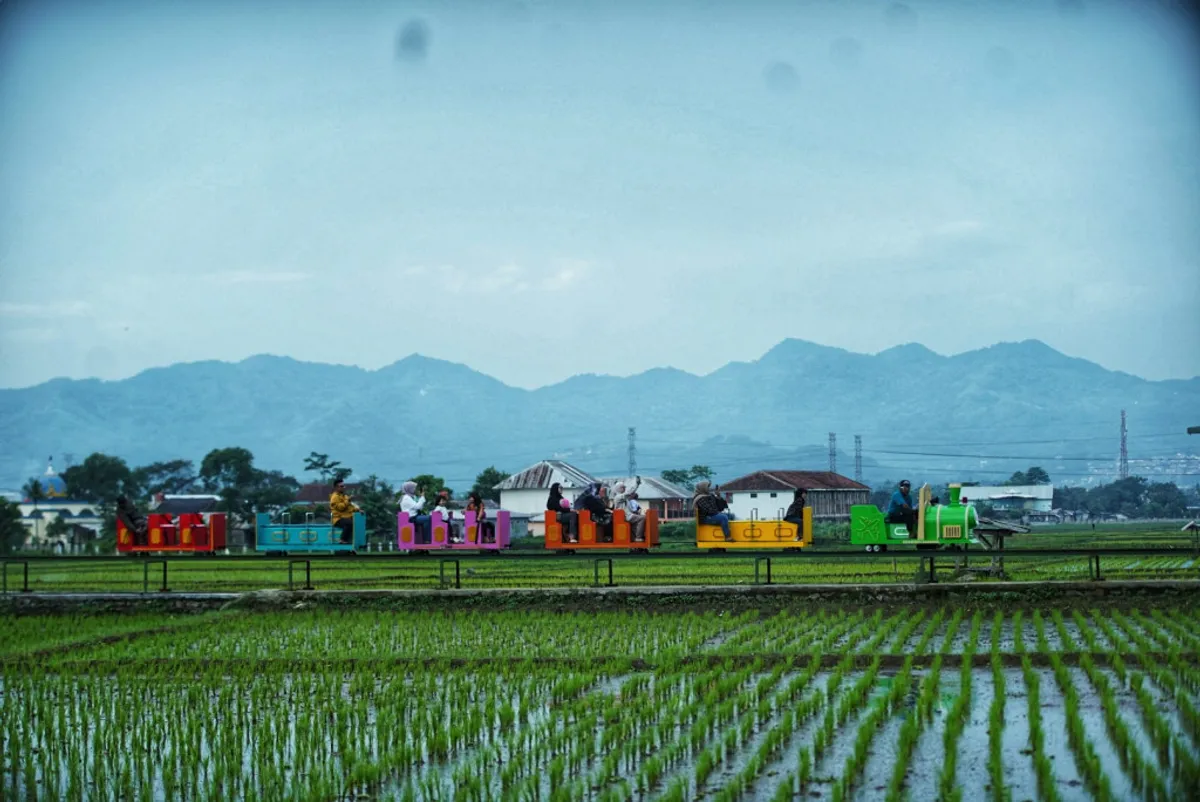 Wisatawan menaiki wahana Kereta Dangdeur Van Java di Ciherang, Desa Kiangroke, Kecamatan Banjaran, Kabupaten Bandung. (Sumber: Ayobandung | Foto: Kavin Faza)