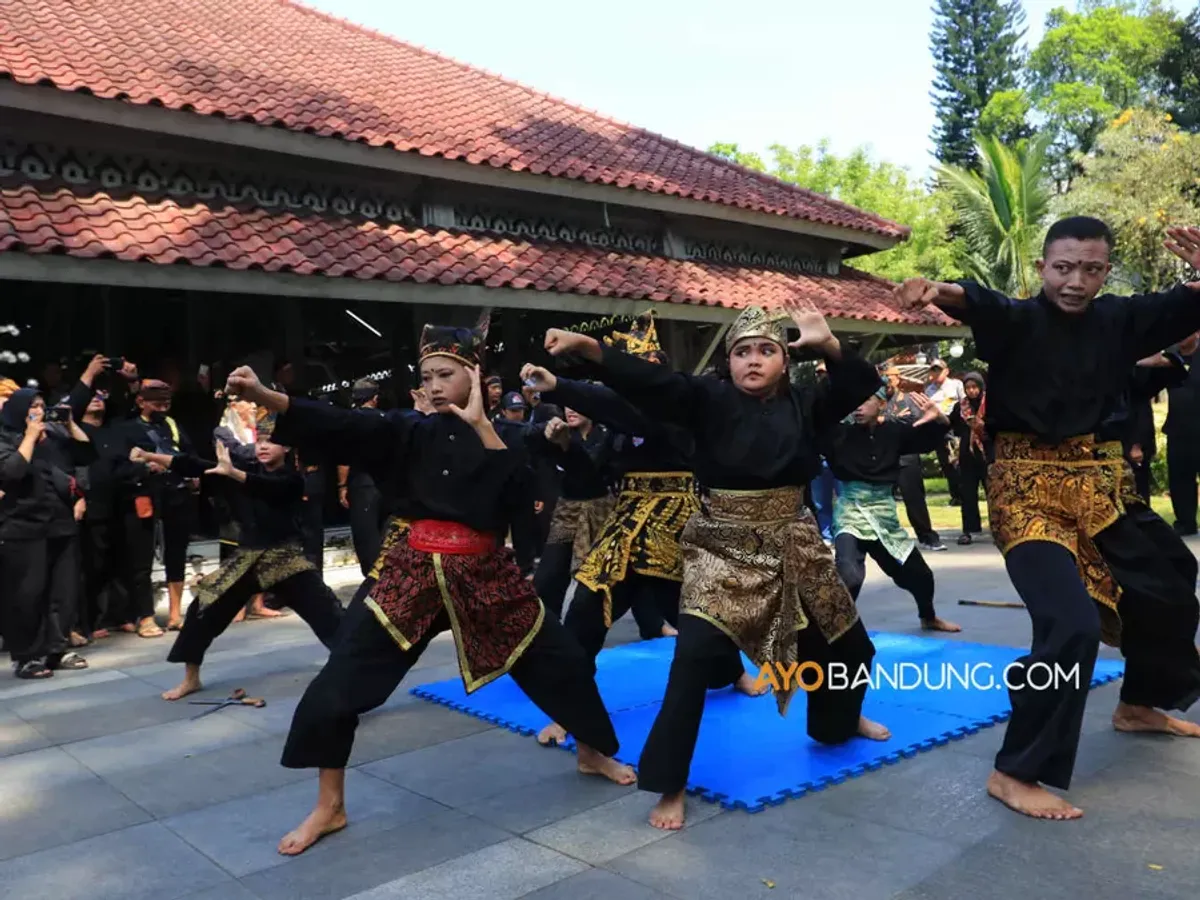 Pesilat dari Paguron Gajah Putih Baleendah menampilkan gerakan pencak silat pada gelaran Bandung Lautan Pangsi di halaman Pendopo Alun-Alun Bandung, Jalan Dalem Kaum, Kota Bandung, Selasa 11 Juli 2023. Gelaran yang bertema "Pangsi Pusaka Karuhun Nusantara" diinisiasi oleh Jaga Lembur dan Pakarang Adat dalam rangka melestarikan atau ngamumule budaya Sunda. (Sumber: ayobandung.com | Foto: Irfan Al-Faritsi)