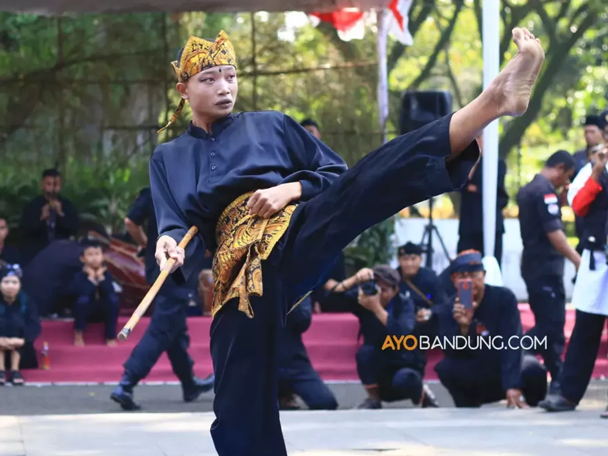 Pesilat dari Paguron Gajah Putih Baleendah menampilkan gerakan pencak silat pada gelaran Bandung Lautan Pangsi di halaman Pendopo Alun-Alun Bandung, Jalan Dalem Kaum, Kota Bandung, Selasa 11 Juli 2023. Gelaran yang bertema "Pangsi Pusaka Karuhun Nusantara" diinisiasi oleh Jaga Lembur dan Pakarang Adat dalam rangka melestarikan atau ngamumule budaya Sunda. (Sumber: ayobandung.com | Foto: Irfan Al-Faritsi)