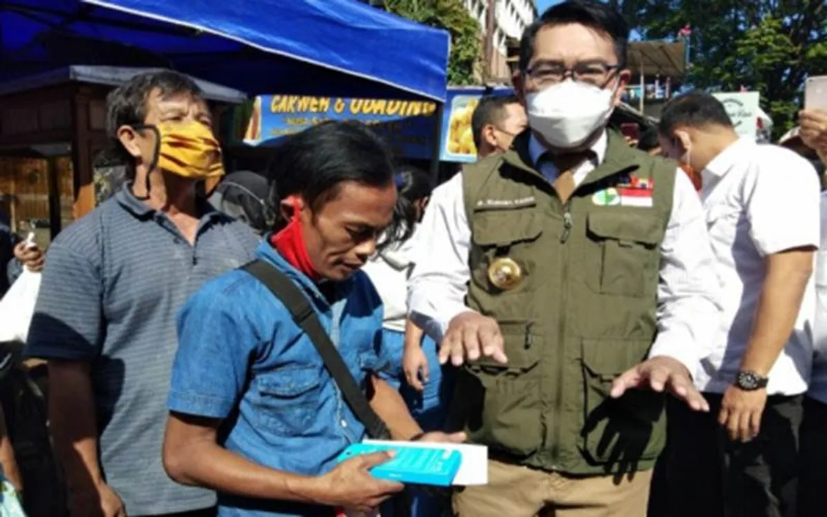 Ridwan Kamil saat memberikan HP kepada Ade Londok. (Sumber: Pemprov Jabar)