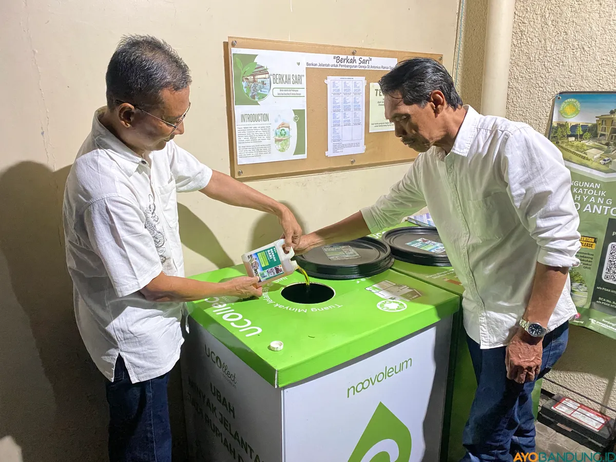 Inisiator BERKAH SARI Yosafat Nugroho dan Antonius Sapto M bersama menuangkan sekompan kecil jelantah ke tabung UCOllet di Gereja Katolik Hati Tak Bernoda Santa Perawan Maria, Cijagra, Buahbatu Kota Bandung pada Selasa, 7 Oktober 2025. (Sumber: ayobandung.id | Foto: Ikbal Tawakal)