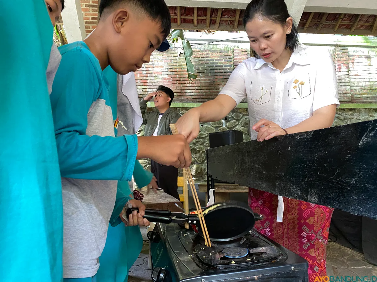 Wida sedang mengajarkan kepada murid-murid sekolah dasar cara memasak eggroll dari singkong pada Kamis, 16 Oktober 2025. (Sumber: ayobandung.id | Foto: Ikbal Tawakal)
