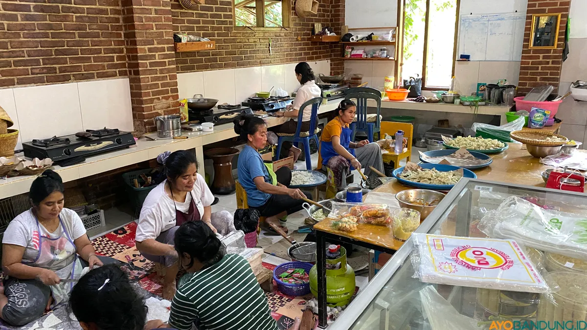 Para ibu-ibu terlihat sibuk dan telaten mengolah olahan singkong mulai dari mengupas, memotong menggiling, hingga menggoreng di Rumah Olahan Singkong UMKM Kampung Adat Cireundeu. (Sumber: ayobandung.id | Foto: Ikbal Tawakal)