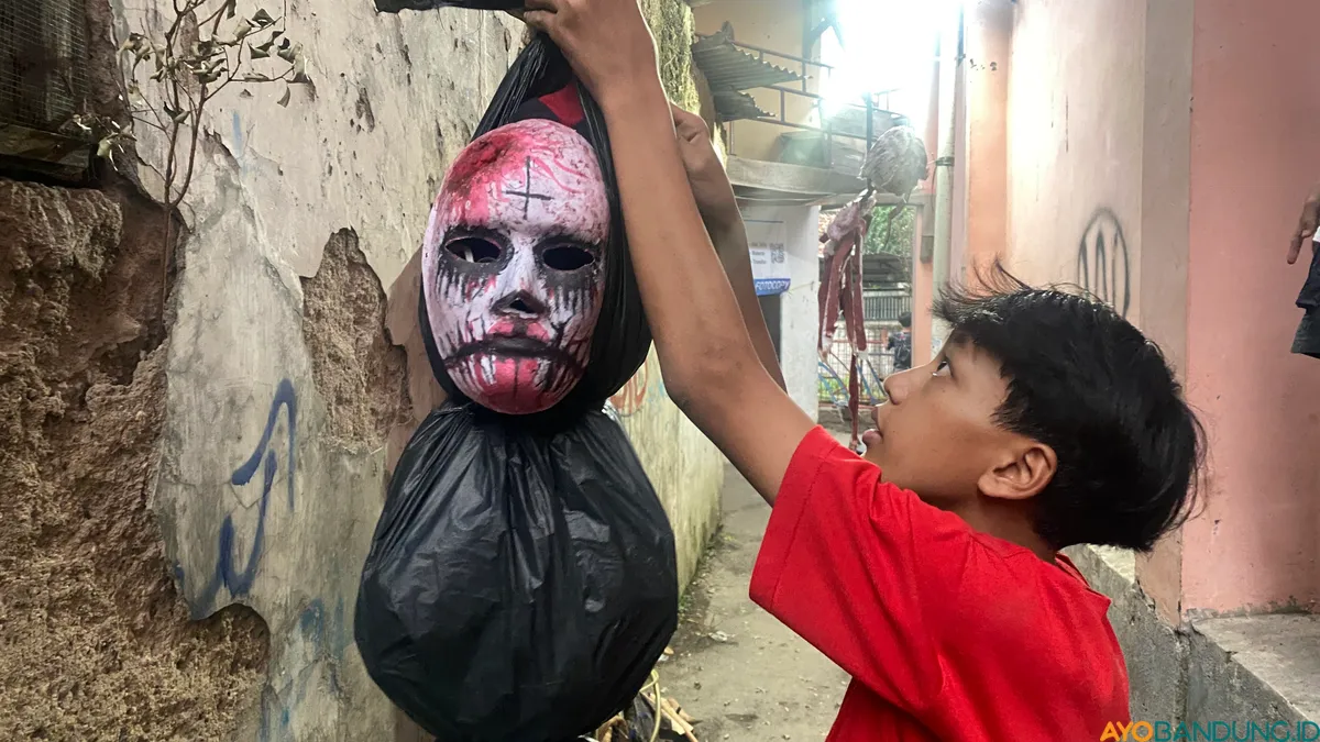 Seorang pemuda mempersiapkan hiasan untuk membuat kesan Lembur Jurig semakin seram. (Sumber: ayobandung.id | Foto: Ikbal Tawakal)