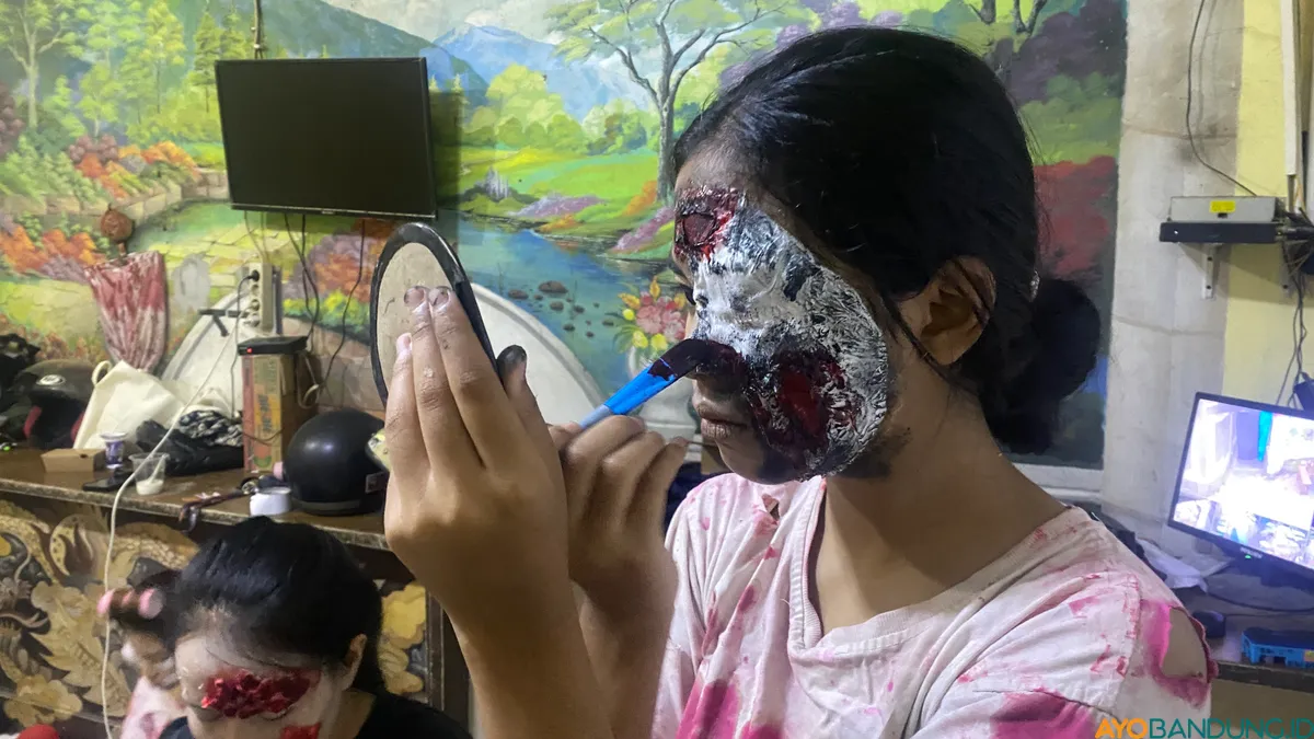 Seorang pemain hantu-hantuan Lembur Jurig merias wajahnya agar bisa tampil menakutkan. (Sumber: ayobandung.id | Foto: Ikbal Tawakal)