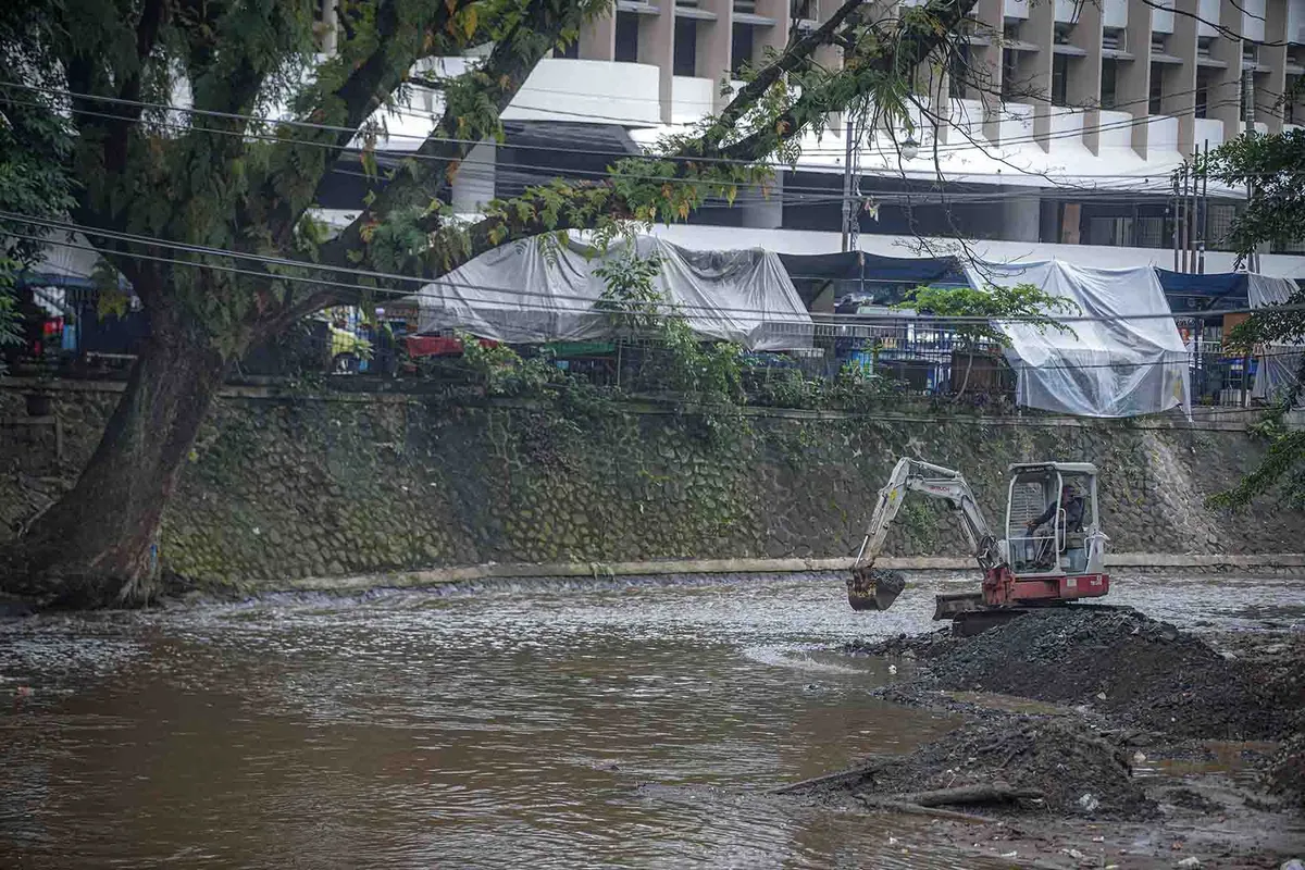 Proses pengerukan sedimentasi Sungai Cikapundung oleh petugas menggunakan alat berat di Kota Bandung. (Sumber: Ayobandung.id | Foto: Kavin Faza)