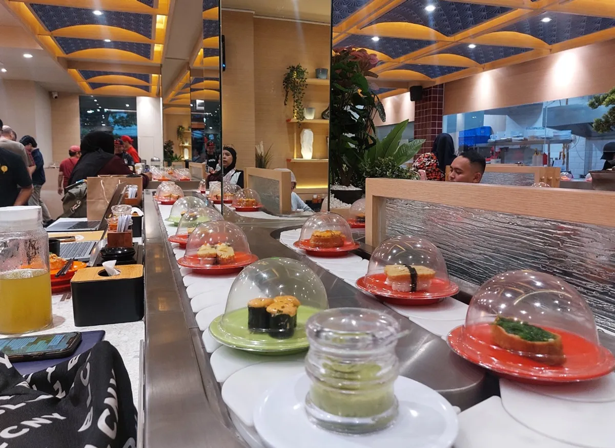 Jika dulu makanan Jepang identik dengan restoran eksklusif dan sajian formal, kini hadir cara baru yang lebih dinamis dan interaktif yakni sushi konveyor. (Sumber: Ayobandung.id | Foto: Eneng Reni Nuraisyah Jamil)