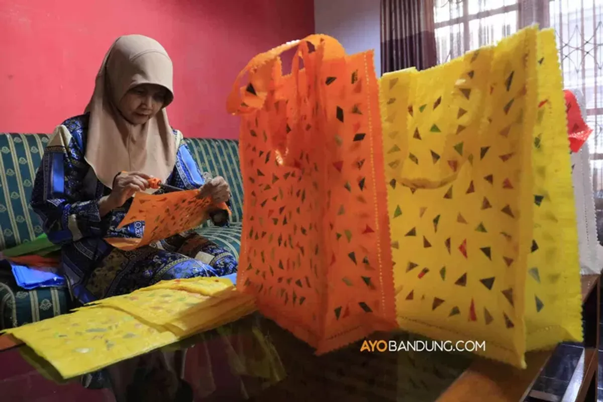 Perajin menyelesaikan produksi kerajinan tas belanja dari limbah plastik di rumah produksi Kekeresekan Bandung. (Sumber: ayobandung.com | Foto: Irfan Al-Faritsi)