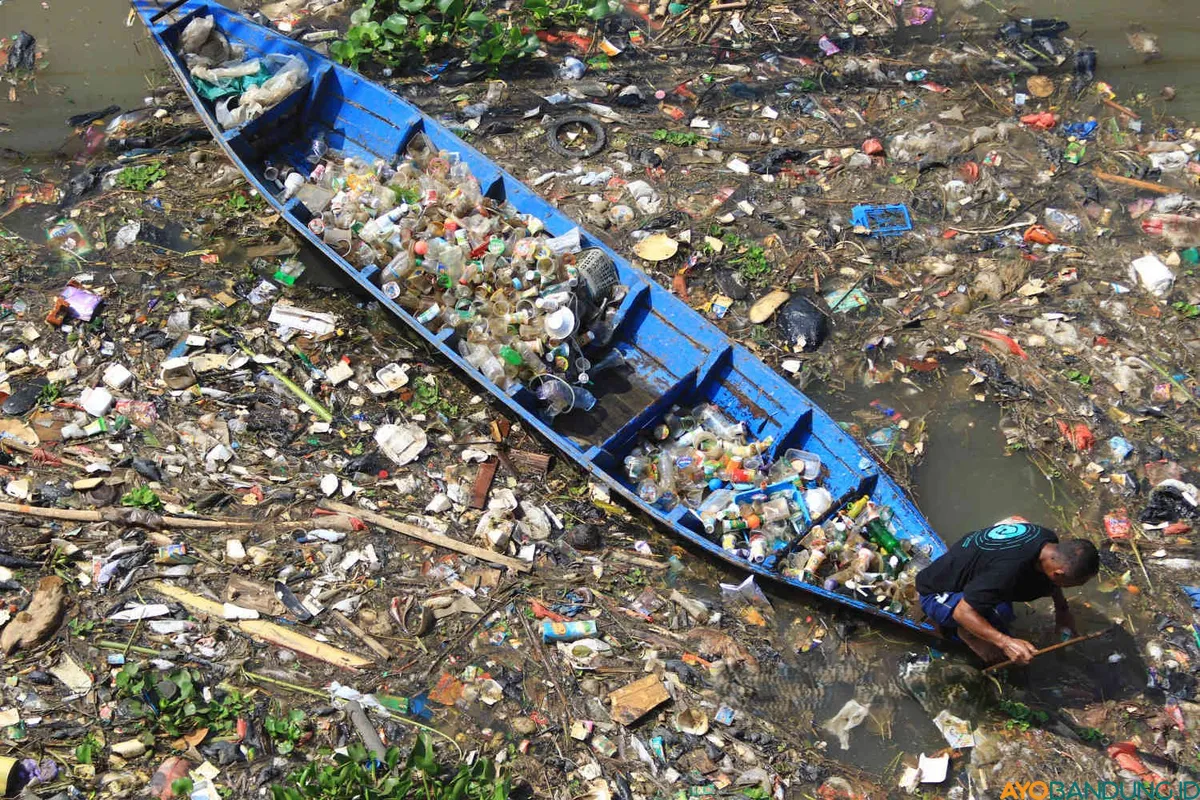 Warga memungut sampah botol dan gelas plastik di bawah jembatan Babakan Sapan (BBS) Batujajar, Kabupaten Bandung Barat (KBB), Jumat 30 Juni 2025. (Sumber: ayobandung.id | Foto: Irfan Al-Faritsi)