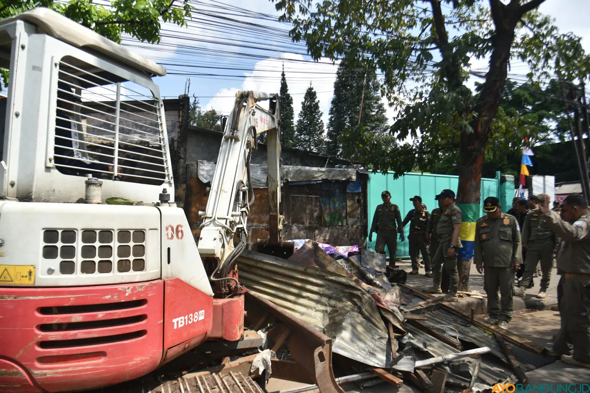 Satpol PP Kota Bandung membongkar lapak pedagang yang berdiri semi permanen di atas trotoar. (Sumber: ayobandung.id | Foto: Gilang Fathu Romadhan)