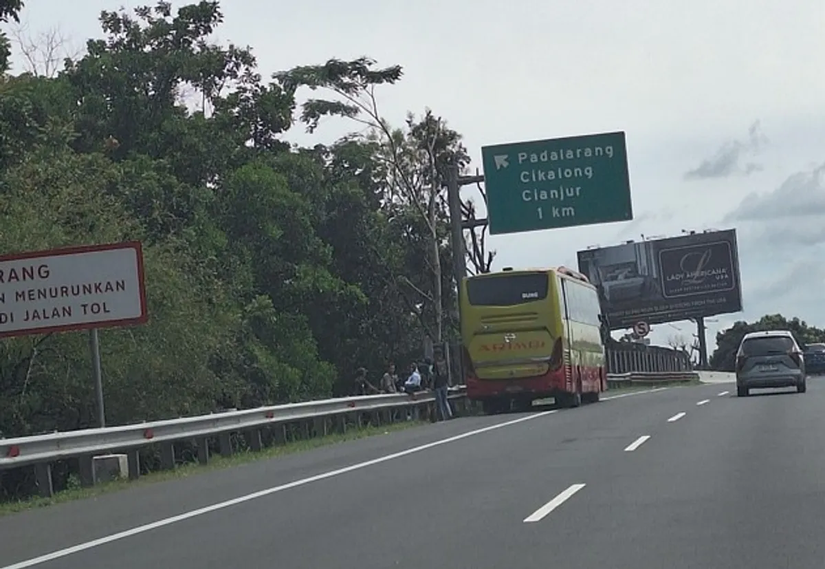 Bus antarkota sedang menaikkan penumpang di bahu jalan Tol Purbaleunyi, Selasa (24/3/2026). (Foto: Angga Marditama Sultan Sufanir)