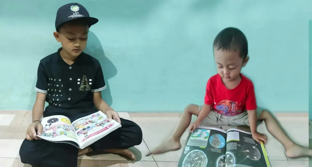 Aa Akil (10 tahun), Kakang (4 tahun) sedang asyik membaca di perpustakaan alakadarnya. (Sumber: Istimewa | Foto: IBN GHIFARIE)