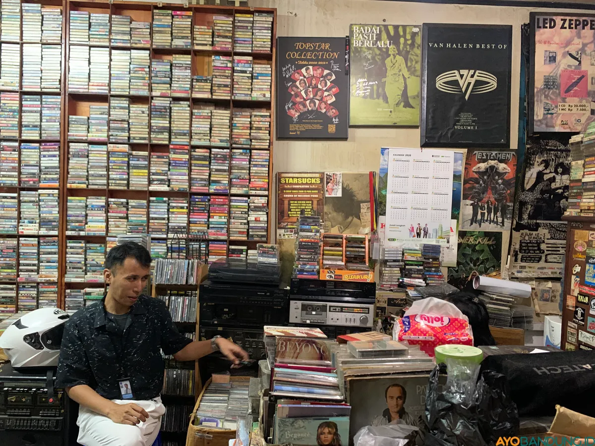 Rak-rak kayu penuh kaset dan vinyl menyimpan jejak musik lintas generasi. (Sumber: ayobandung.id | Foto: Halwa Raudhatul)