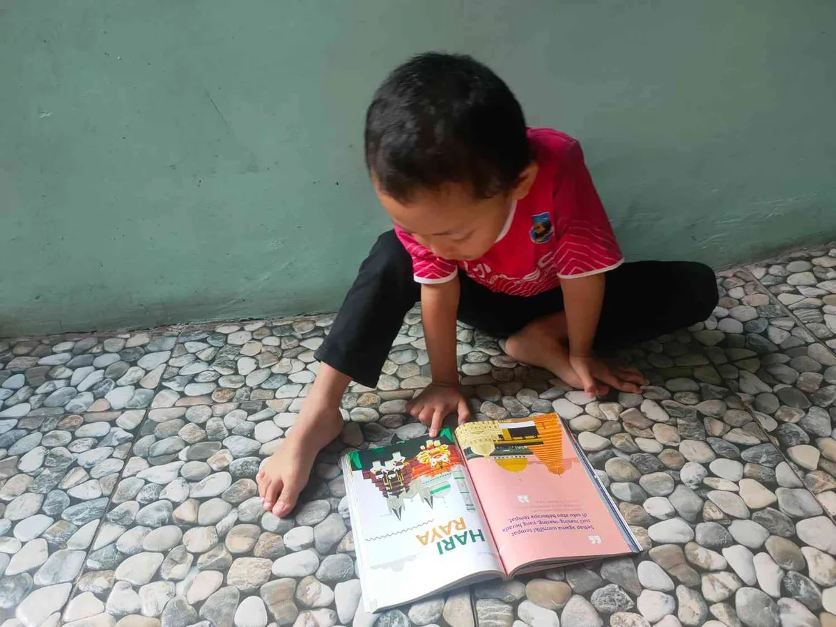 Kakang anak ketiga tengah asyik melihat gambar, Ahad (26/4/2026) (Sumber: Istimewa | Foto: IBN GHIFARIE)