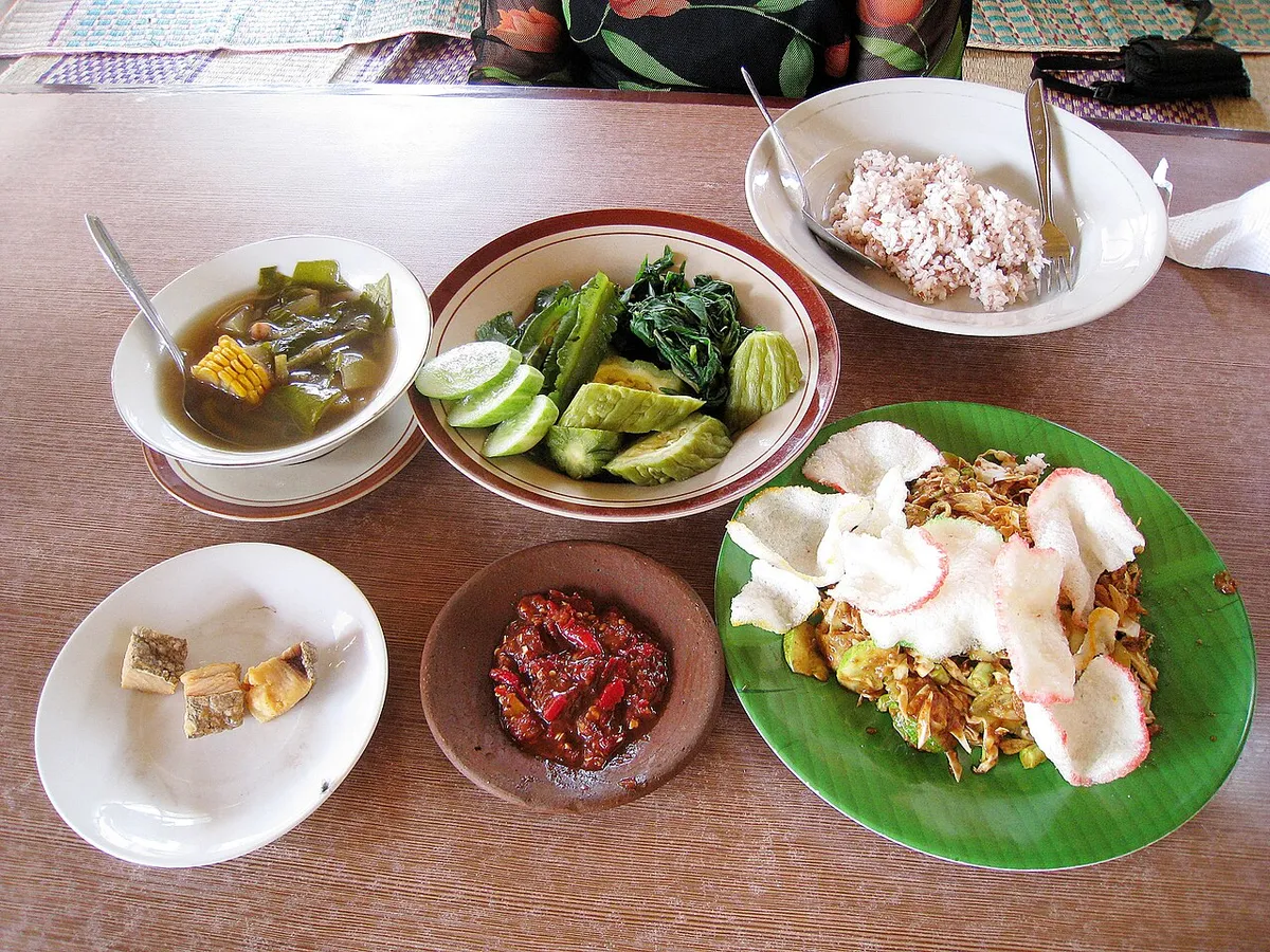 Hidangan Sunda berupa sayur asem, lalab, nasi merah, ikan asin, sambal, dan karedok. (Sumber: Wikimedia Commons | Foto: Gunawan Kartapranata)