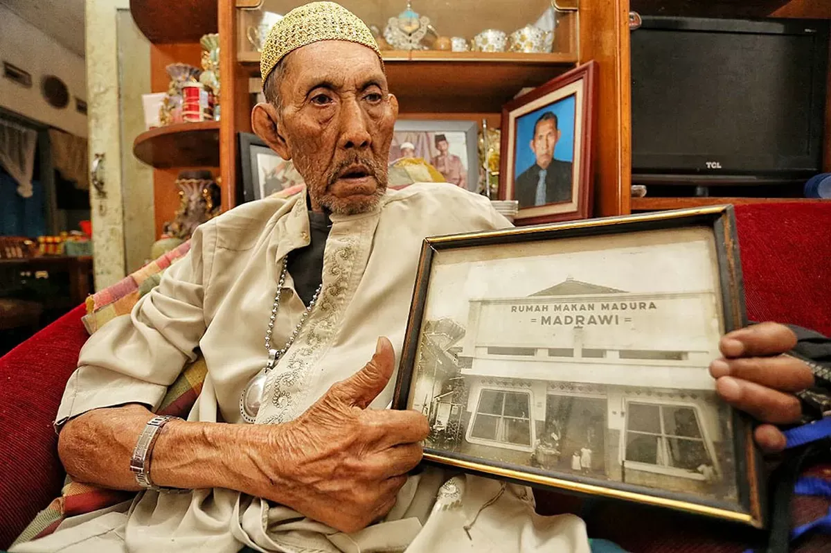 Fadli Badjuri menunjukkan foto rumah makan (RM) Madrawi tempo dulu di kediamannya di Kota Bandung, Selasa (17/4/2018). (Sumber: Humas Pemkot Bandung)