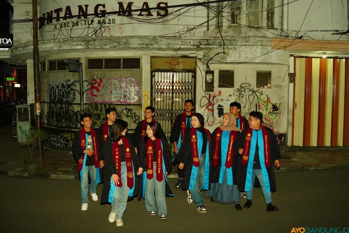 Bosan dengan foto studio, sekelompok mahasiswa yang baru selesai wisuda berfoto bersama di Jalan ABC, Kota Bandung. (Sumber: ayobandung.id | Foto: Ilham Maulana)