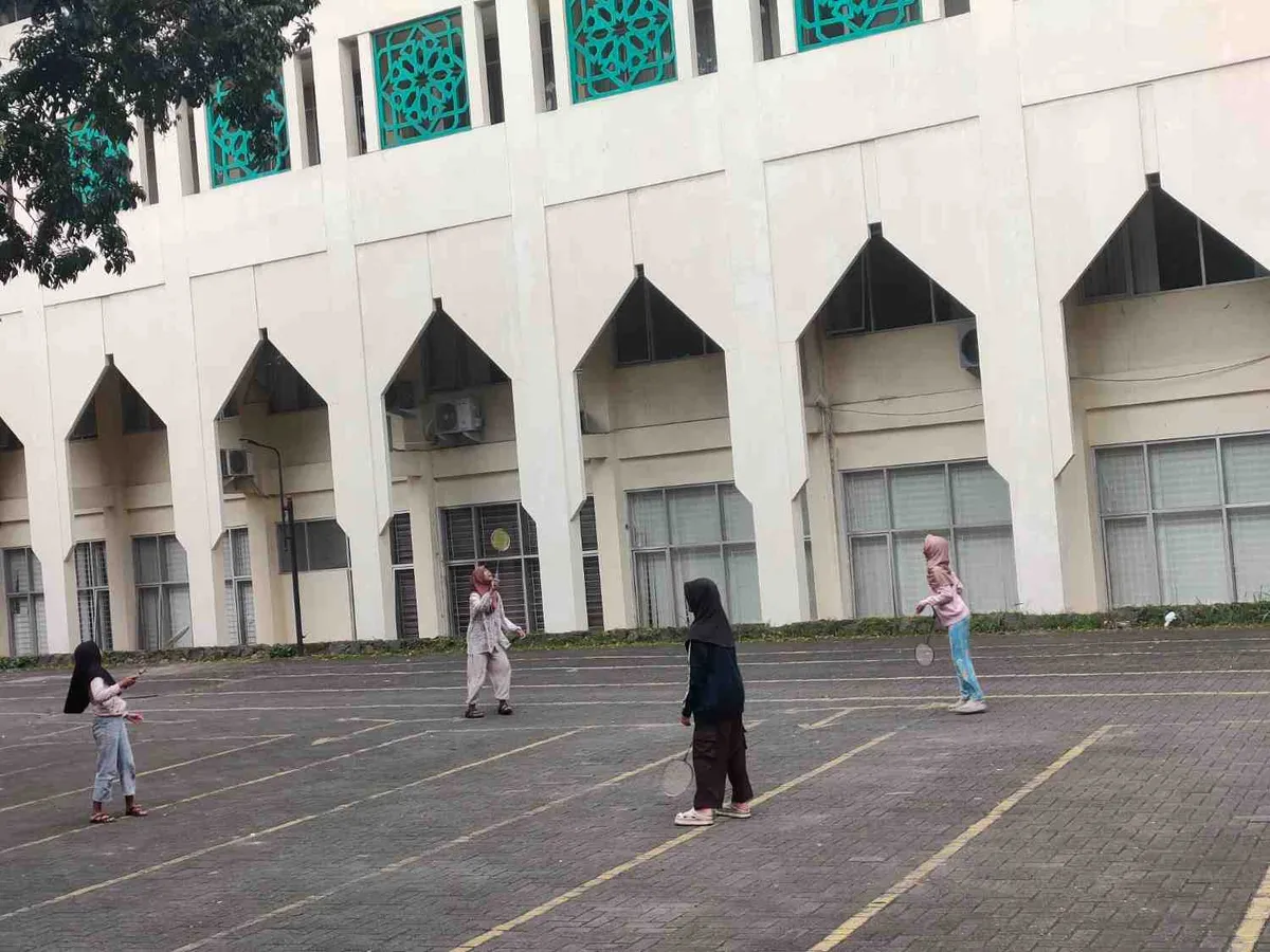 Empat orang perempuan tengah asyik ngabeubeurang sambil bermain badminton di depan GOR Kampus I UIN Bandung, Kamis 19 Februari 2026 (Sumber: Istimewa | Foto: IBN GHIFARIE)