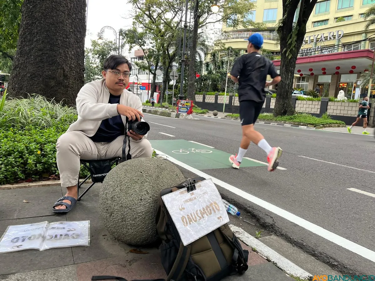 Daus rajin memotret pelari pagi di kawasan Dago, Kota Bandung. Dari semula hobi kini jadi pekerjaan sampingan. (Sumber: ayobandung.id | Foto: Ilham Maulana.)