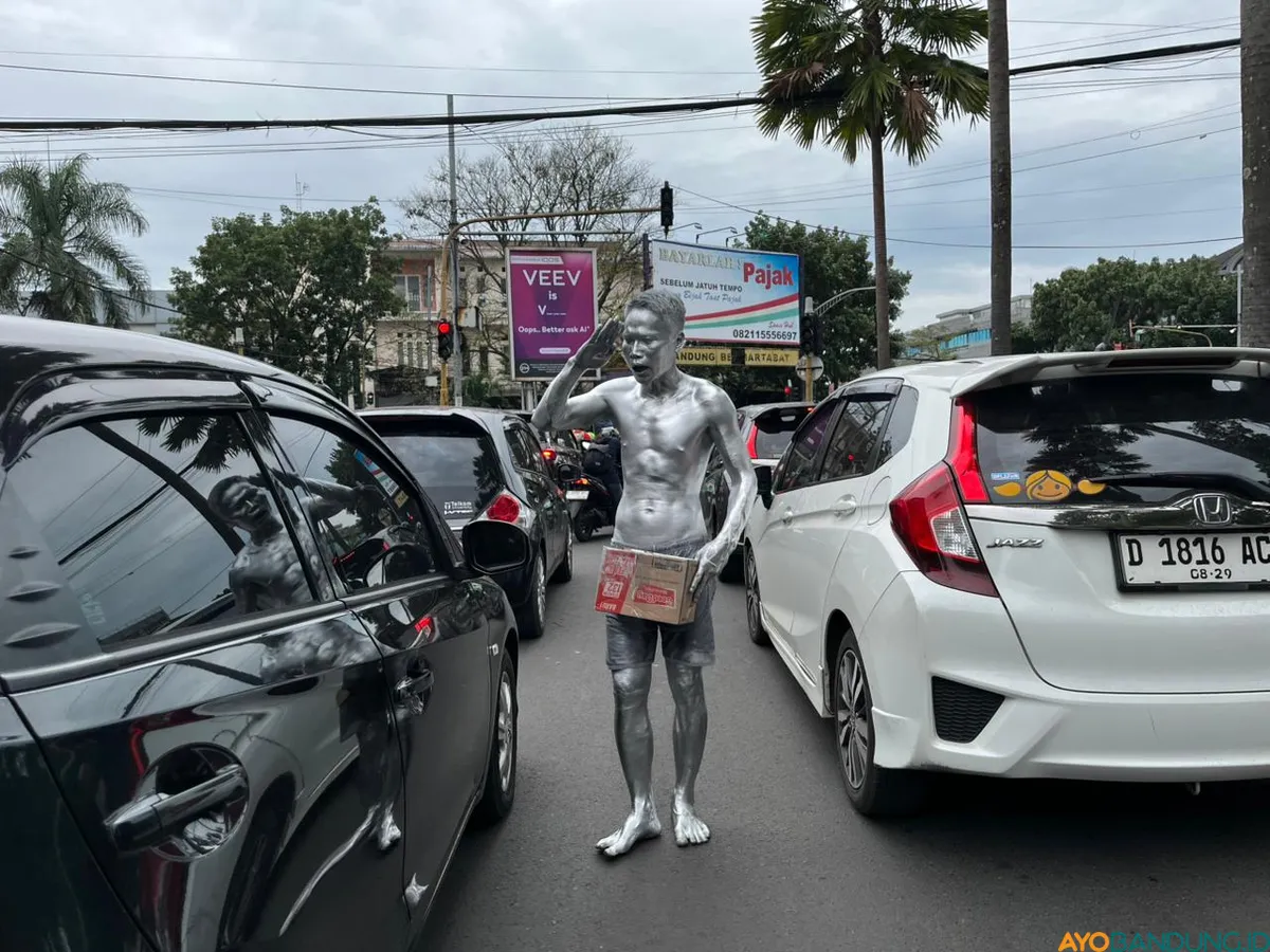 Melumuri badannya dengan cat sablon perak, Erwin sehari-hari mangjal di kawasan Jalan Pelajar Pejuang, Kota Bandung. (Sumber: ayobandung.id | Foto: Ilham Maulana)