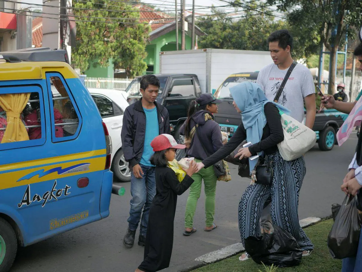 Inisiator Jadi Baik, Zahid Izzah Robbani, saat membagikan paket makanan ke kaum duafa di kawasan Sukasari, Bandung, Selasa (10/4/2018). (Sumber: AyoBandung.com | Foto: Fathia Uqim)