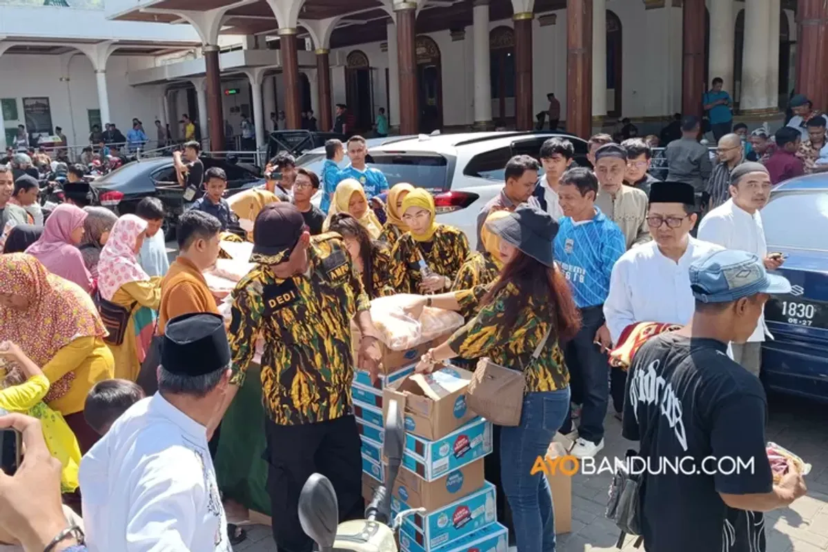 Proses pembagian roti kemasan dan air mineral secara gratis pada warga yang telah melaksanakan solat jumat. (Sumber: Ayobandung.com | Foto: Muhamad Rifki Mahfudin)