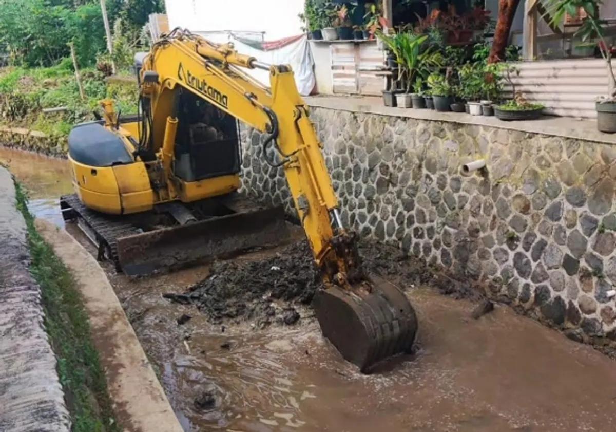 Excavator mengeruk sedimen tanah di sungai Cikasungka. (Sumber: Dokumen ketua RT 03 | Foto: Dadang S. Faruq)