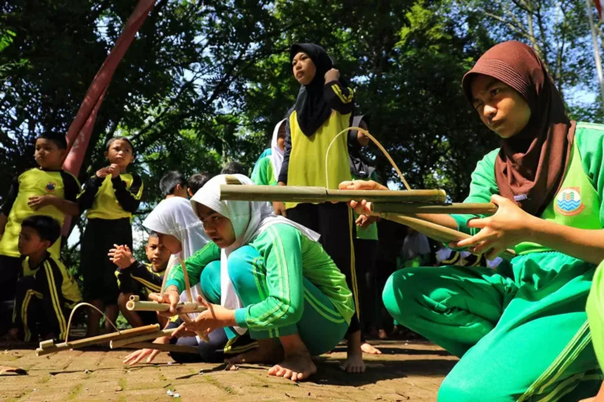 Sejumlah siswa SD Cirendeu saat bermain permainan tradisional, seperti egrang, bakiak batok, bedil jepret dan perepet jengkol, dalam rangkaian acara Festival Cirendeu 2024 di halaman sekolah SD Cirendeu, Kelurahan Leuwigajah, Kecamatan Cimahi Selatan, Kota Cimahi, Sabtu 7 Desember 2024. (Sumber: Ayobandung.com | Foto: Irfan Al-Faritsi)