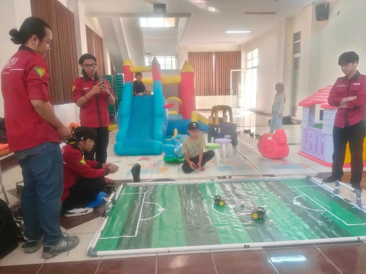 Asyiknya Aa Akil tengah bermain Robot Soccer Junior saat Reuni Akbar 20 Tahun Fakultas Sains dan Teknologi (FST) di Gedung Anwar Musaddad, Sabtu (4/7/2026) (Sumber: Istimewa | Foto: IBN GHIFARIE)
