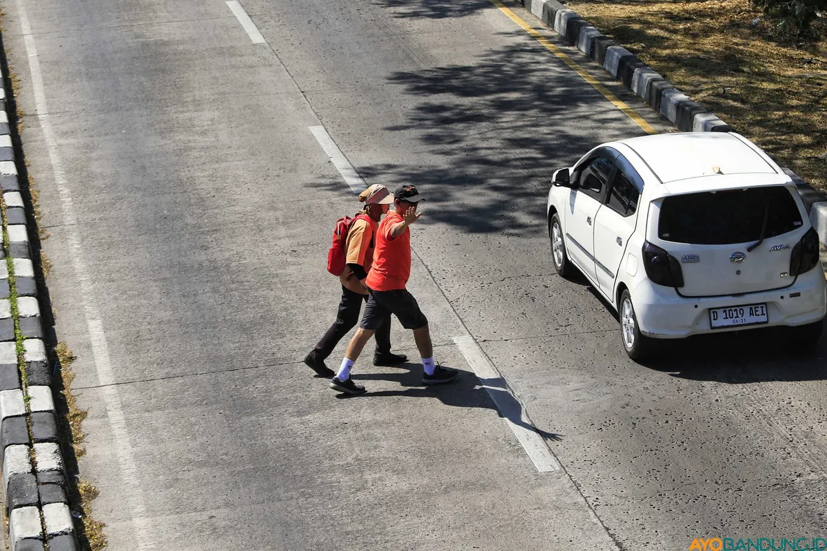 Akibat minimnya Jembatan Penyeberangan Orang, warga melintas di jalan Soekarno Hatta Bandung, Senin 13 Juli 2026. (Sumber: ayobandung.id | Foto: Irfan Al Faritsi)