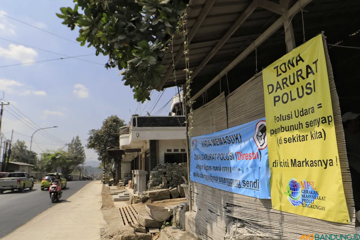 Spanduk peringatan dari Gerakan Masyarakat Peduli Lingkungan (Gampil) terpasang di kawasan Cipatat sebagai bentuk protes warga terhadap dampak aktivitas industri batu gamping. (Sumber: ayobandung.id | Foto: Irfan Al Faritsi)