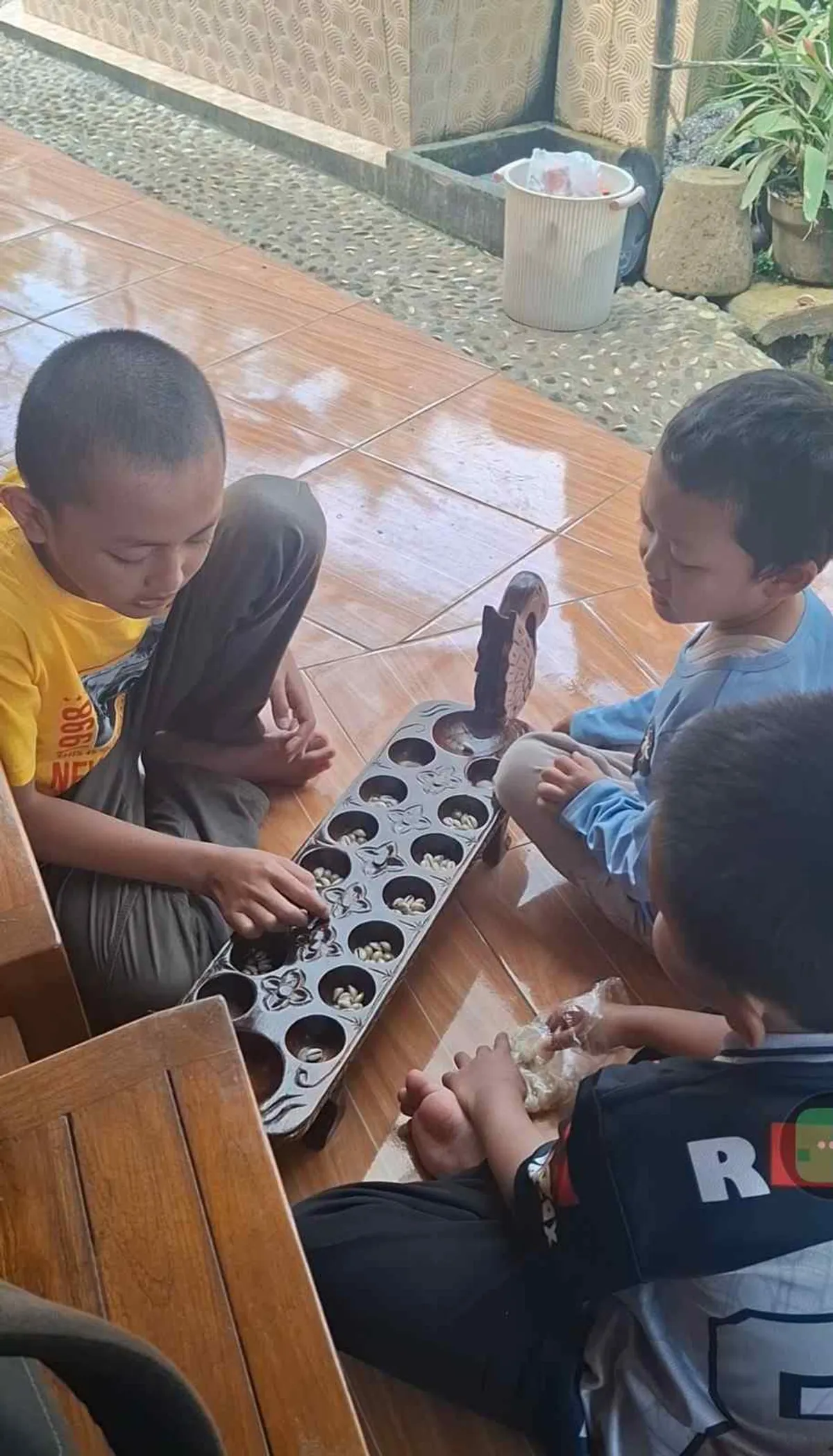 Aa Akil, Affan dan Kakang main congklak di Pondok Tandang Bakti Cigendel, Kecamatan Pamulihan, Kabupaten Sumedang, Ahad (31/5/2026) (Sumber: Istimewa | Foto: Mang Ali)